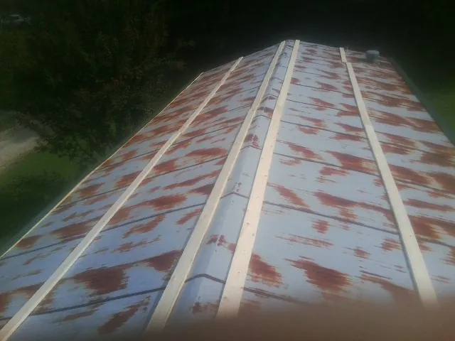Rusted metal roof panels with new wood purlins before replacement — Storm Damage Roof Repair in Tehuacana by Roofing Brothers