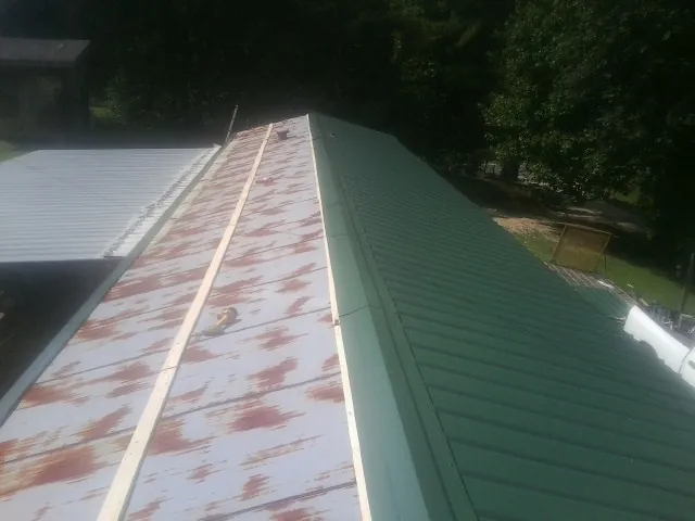 Old rusted panels beside newly installed green metal roofing — Wind Damage Roof Repair by Roofing Brothers in Tehuacana