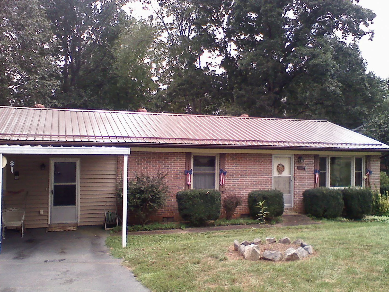 Bronze metal roof and carport on a brick ranch home — Roof Repair work by our crew in Tehuacana